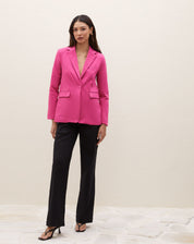 Blazer rosa com lapela e bolsos com aba, modelo em pose completa.