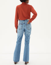 Vista traseira da calça jeans flare azul claro.