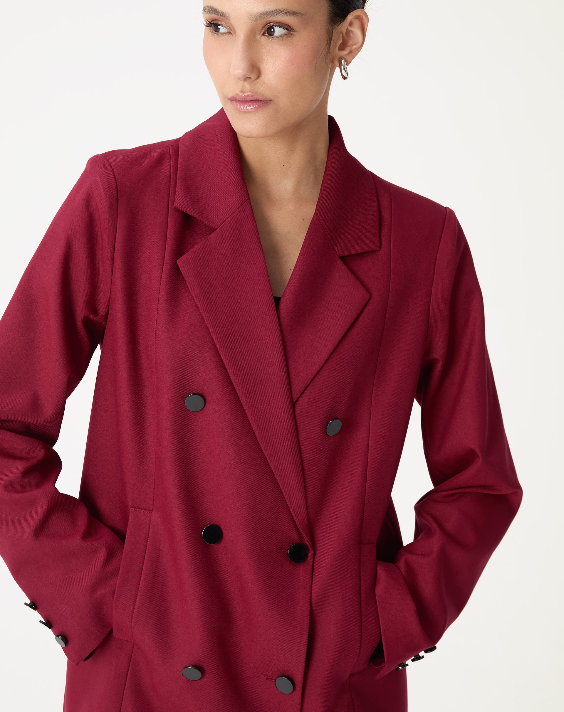 Foto de meia-corpo frontal do blazer oversized vinho com abotoamento duplo e bolsos embutidos em fundo claro.