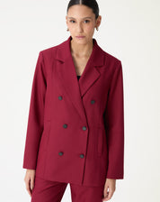 Close da lapela entalhe e dos botões pretos do blazer oversized vinho mostrando o acabamento do tecido plano.