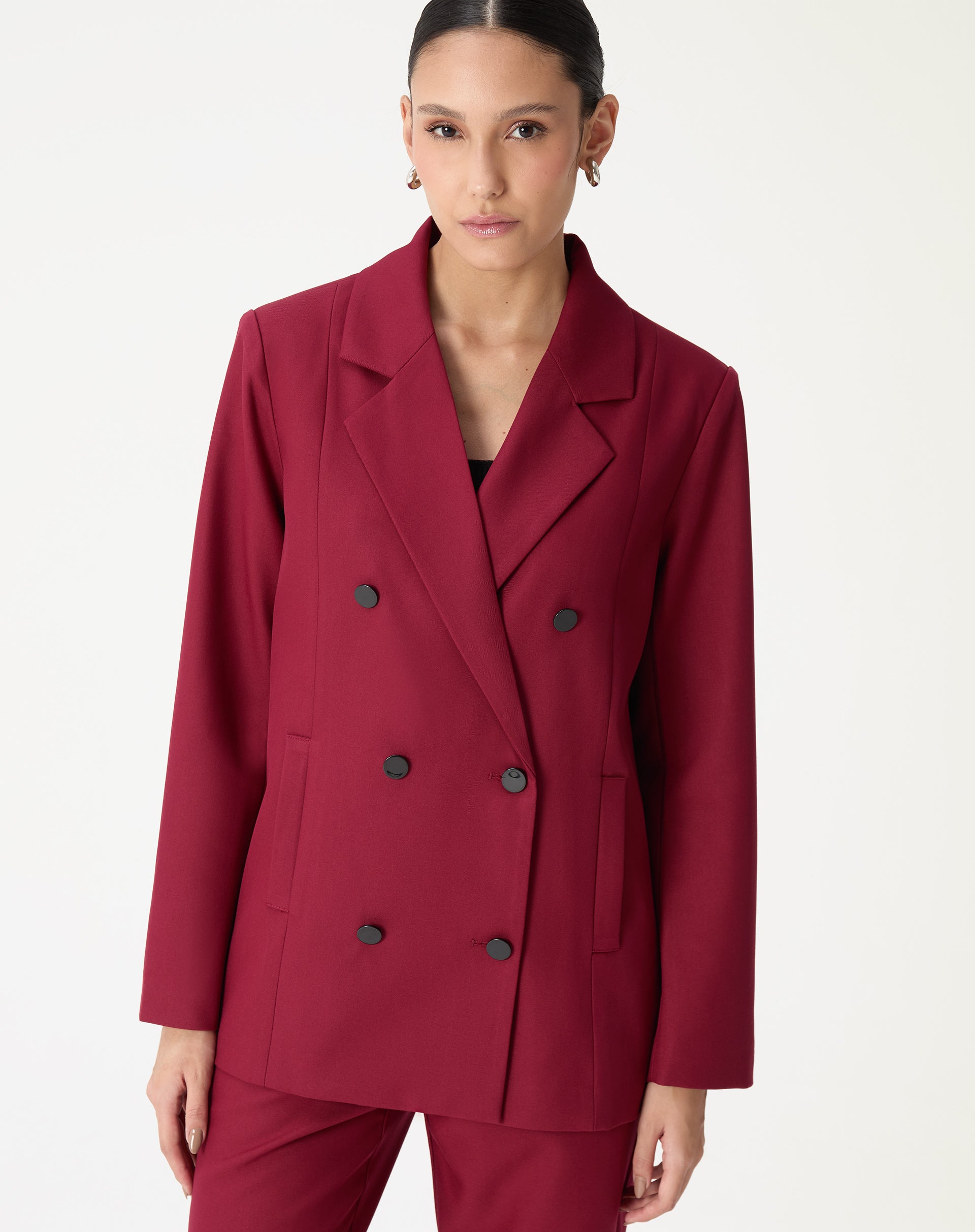 Close da lapela entalhe e dos botões pretos do blazer oversized vinho mostrando o acabamento do tecido plano.
