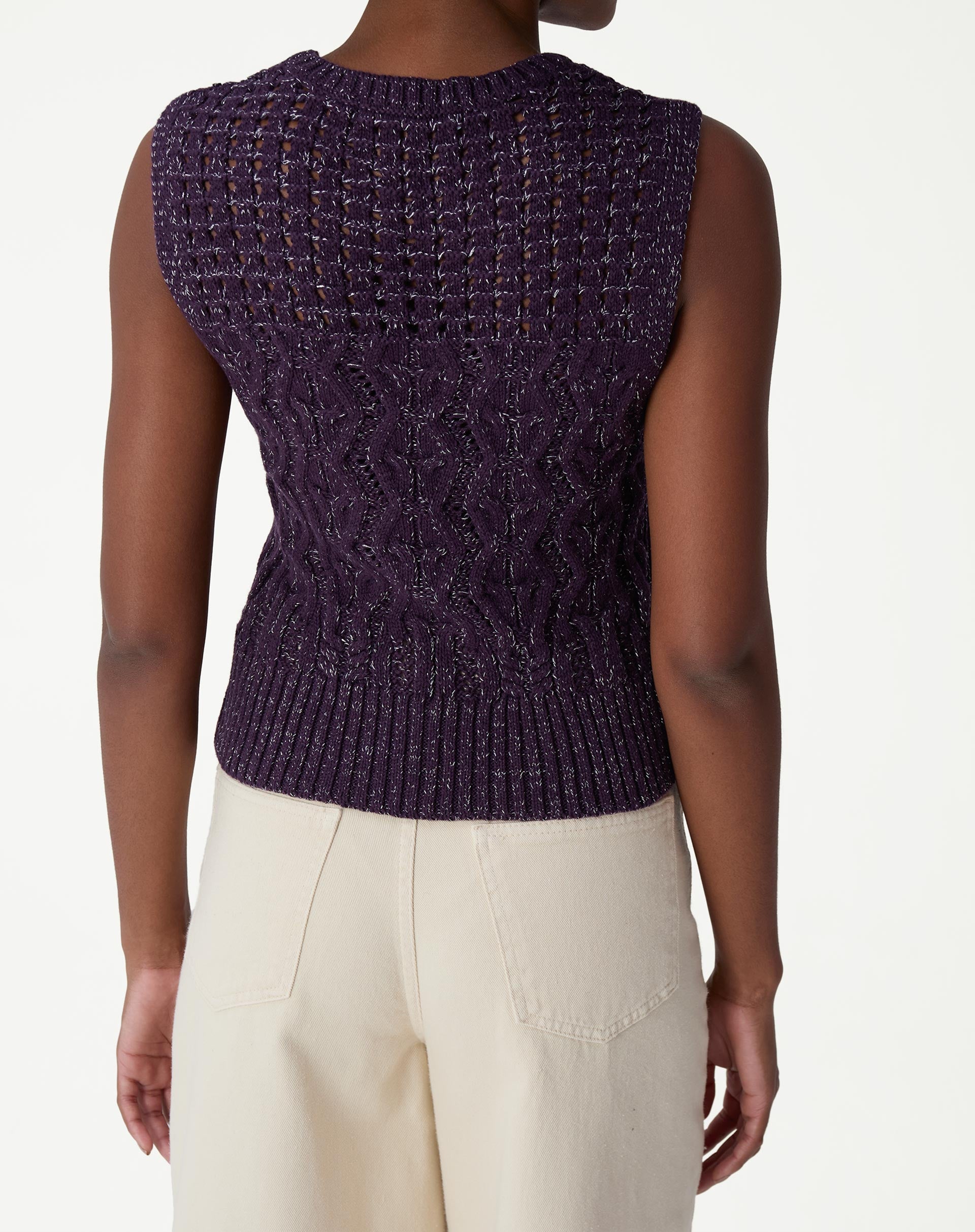 Regata tricot roxa em modelo vista de três quartos, evidenciando o caimento ajustado, comprimento curto e cava sem alças.