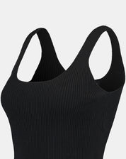 Vista em ângulo da regata tricot preta em close, evidenciando a malha canelada e o acabamento