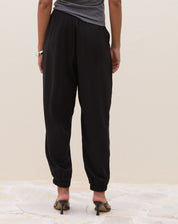 Calça Jogger Aladim preta - vista frontal alongada mostrando caimento largo e bolsos laterais discretos